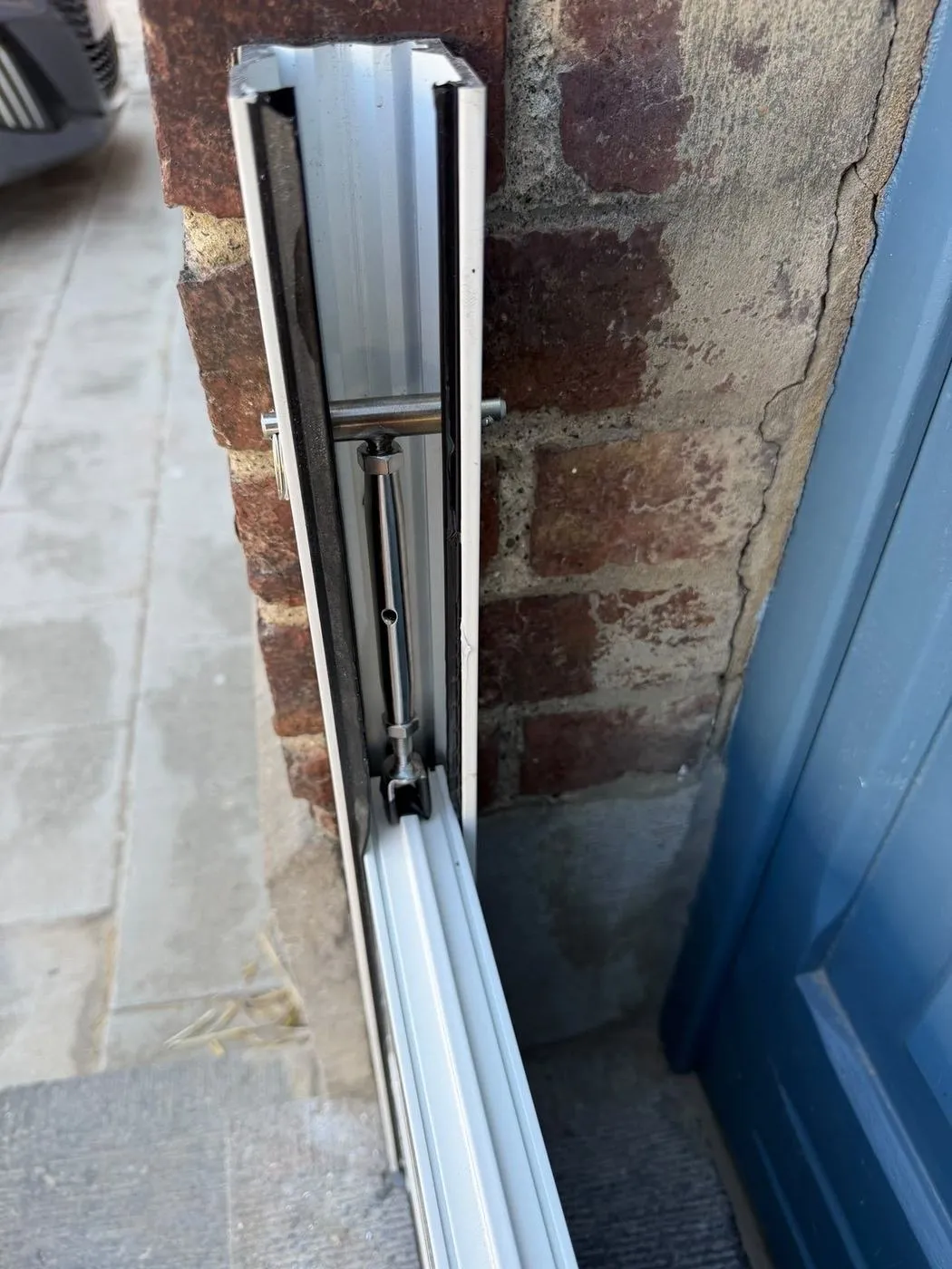 Glissière en aluminium vissée dans le mur en brique
